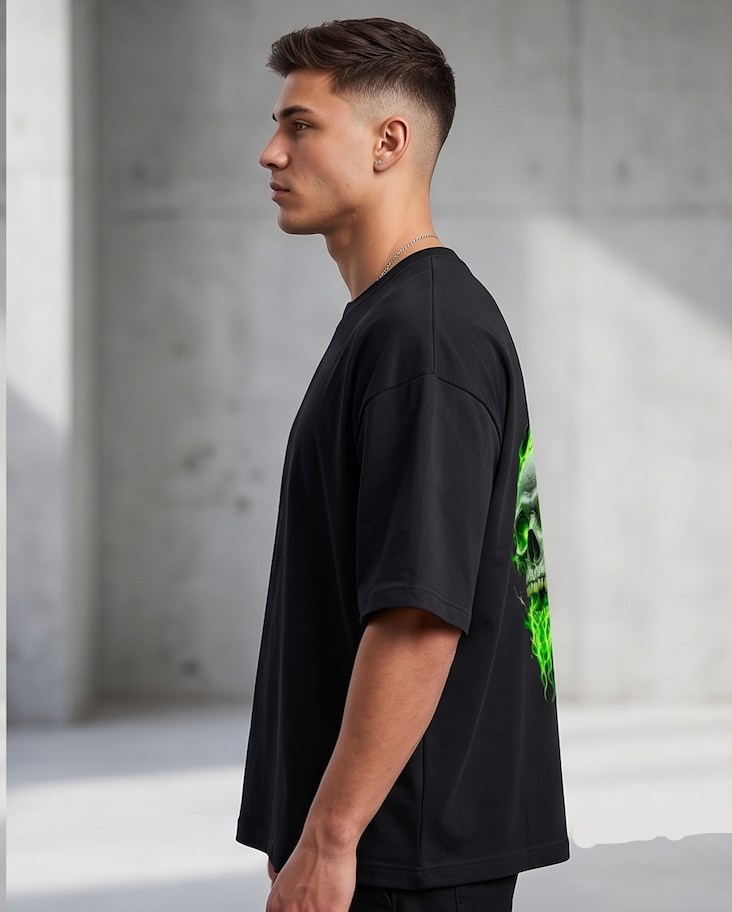 Man wearing a black t-shirt with a green graphic design in a minimalistic setting